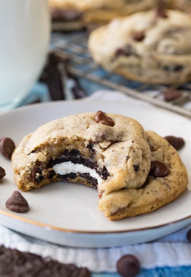 Oreo Stuffed Chocolate Chip Cookies! These are so easy to make and everyone was so surprised when they bit inside! #cookie #chocolatechipcookie #recipe #oreo #dessert #baking #oreocookie #yum #favoriterecipe #easydessert Oreo Stuffed Chocolate Chip Cookie with a bite taken out of it, showing the cookie center