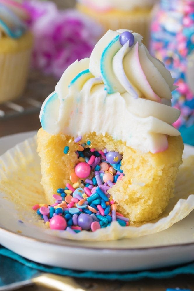 How to Make Pinata Cupcakes! These are so simple to make but they look SO COOL! Add your favorite filling and top with a colorfully swirled frosting! Vanilla Pinata Cupcake Filled with sprinkles