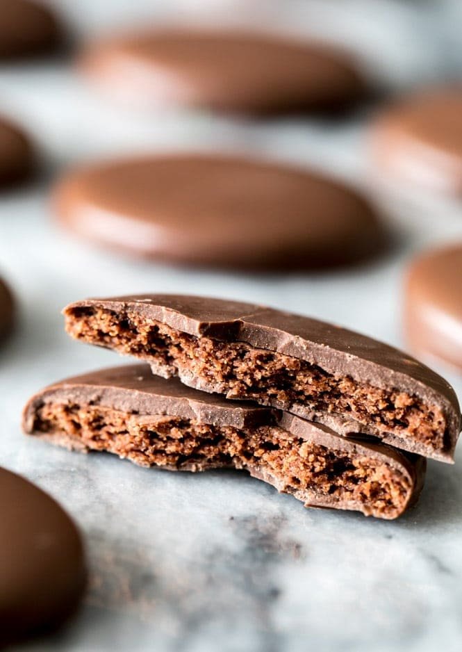 Copycat Thin Mint Cookies! A thin chocolate wafer cookie coated in chocolate, broken in half to showcase the crisp center and chocolate cloak