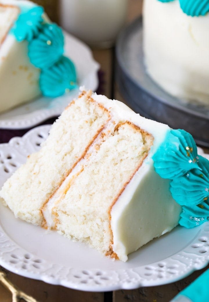 This is the BEST White Cake Recipe! So easy and so light, moist, and fluffy! white cake on a white plate