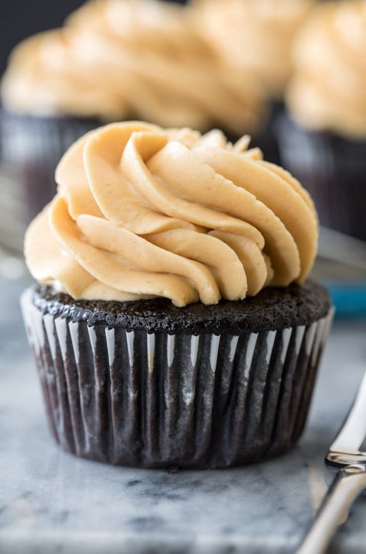 How to make a PEANUT BUTTER FROSTING that's silky smooth but perfectly pipeable, it's the perfect complement to any cake or cupcake. Also great for just eating by the spoonful! #frosting #cupcake #recipe #baking #homemade Peanut butter frosting on a chocolate cupcake