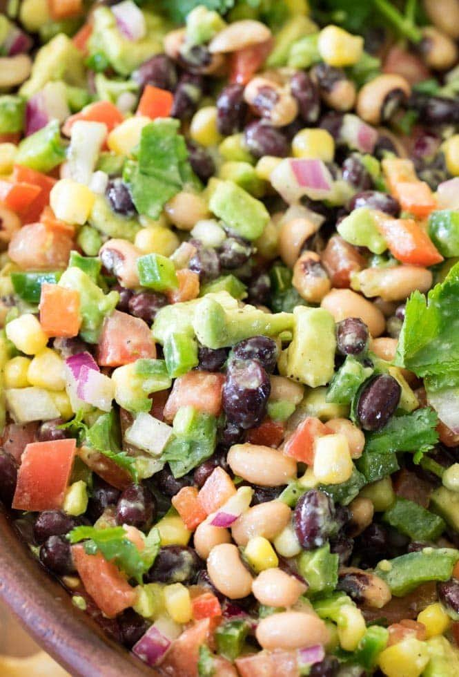 How to make TEXAS CAVIAR! Have you tried this summertime staple!? So good, everyone is going to want the recipe! #texascaviar #summersalad #dip #diprecipe #cookoutfood #partyfood #summerfood A large bowl of Texas Caviar