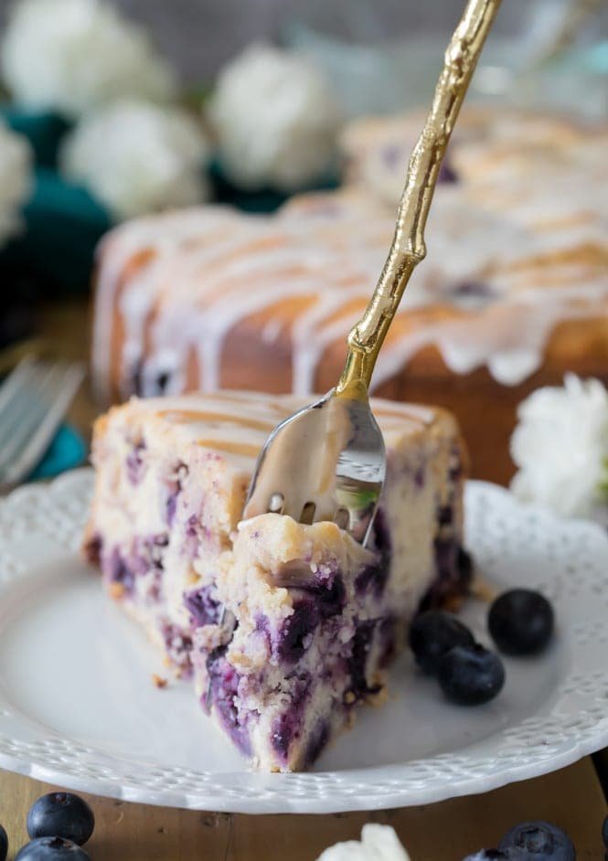 How to make a BLUEBERRY CAKE! Packed full of fresh blueberries and topped off with a lemon glaze, you're going to want to save the recipe for this one! #blueberrycake #cake #recipe #baking #blueberries Fork full of blueberry cake