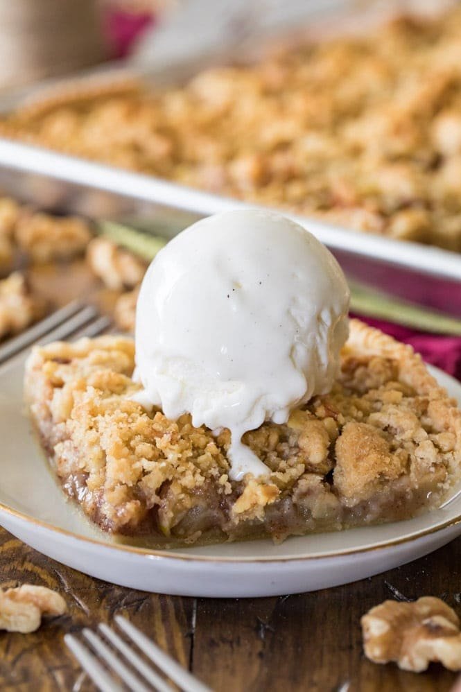 Have you ever made a slab pie? This APPLE SLAB PIE is so simple to make and to serve! #applepie #fallrecipe #fallbaking #applerecipe #Thanksgivingrecipe #thanksgiving slice of apple slab pie topped with ice cream