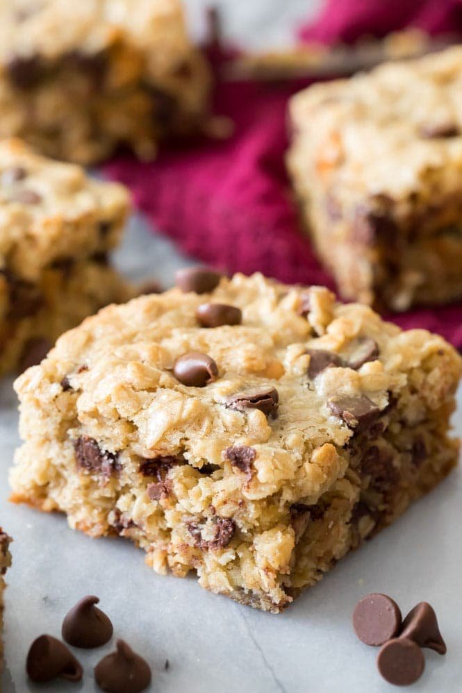 I love these OATMEAL COOKIE BARS! Hearty and packed with chocolate, these are so good! #cookiebar #easyrecipe #barcookie Oatmeal Cookie Bar Square