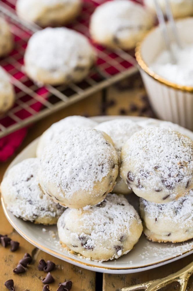 These Chocolate Chip SNOWBALL COOKIES are made egg-free and they positively melt in your mouth! These are so easy and always a hit! #eggfreecookie #snowballcookie #holidaybaking Snowball cookies piled on plate