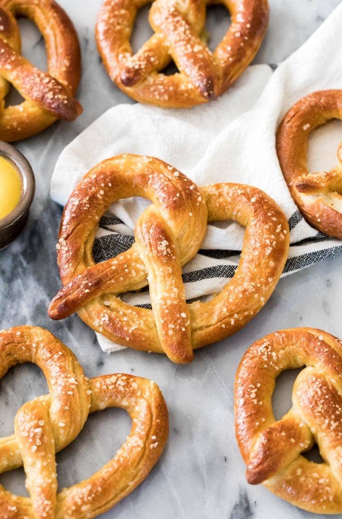 How to make the BEST Soft Pretzels at home! This is a great and carefully explained soft pretzel recipe anyone can make at home! #softpretzels #homebaking Homemade soft pretzel on cloth napkin