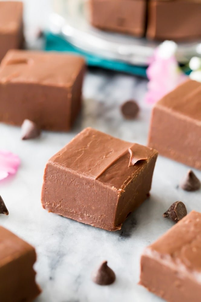 The EASIEST Fudge Recipe! It makes the best fudge! #candyrecipe #fudgerecipe Square of chocolate fudge on marble slab from easy fudge recipe