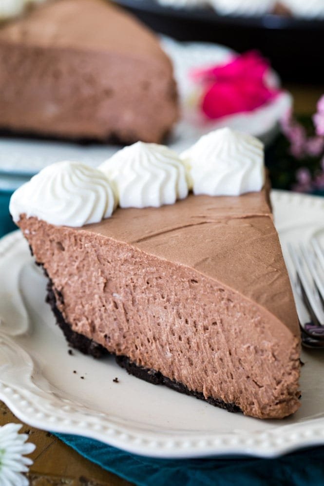 Rich, creamy, NO BAKE Chocolate Icebox Pie! This easy pie recipe is a perfect summertime dessert and there's no oven required! #sugarspunrun #pie #summerrecipe Slice of chocolate icebox pie on white plate