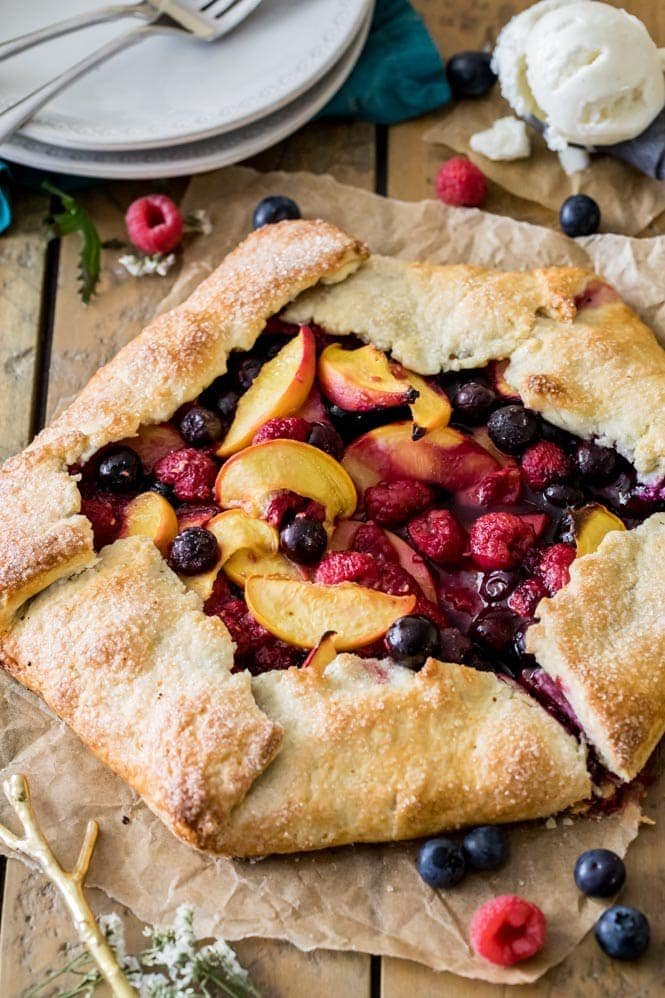 How to make a simple fruit galette recipe! Galettes are easier to make than fruit pies, but every bit as tasty. #summerrecipe #easypierecipe #sugarspunrun #easyaspie Fruit galette on wood board