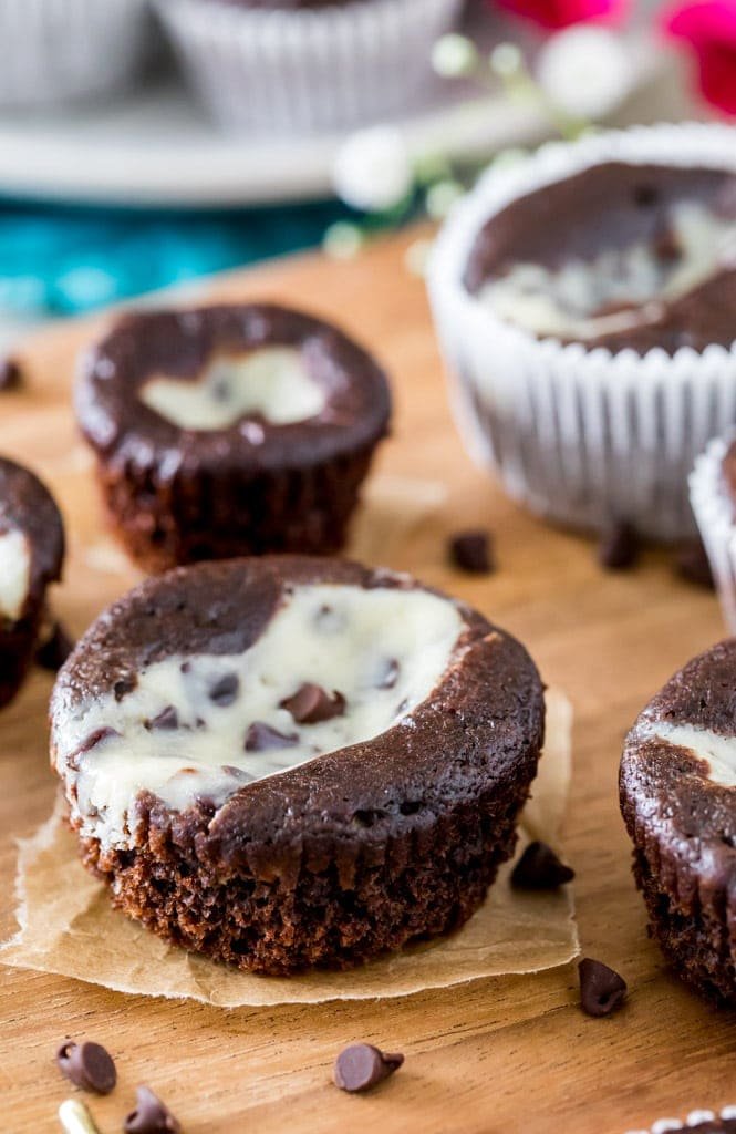 How to make classic BLACK BOTTOM CUPCAKES! Fudgy chocolate bottoms and rich cheesecake centers! So easy and so good! #chocolatecupcakes #blackbottomcupcakes #sugarspunrun black bottom cupcake on wood cutting board