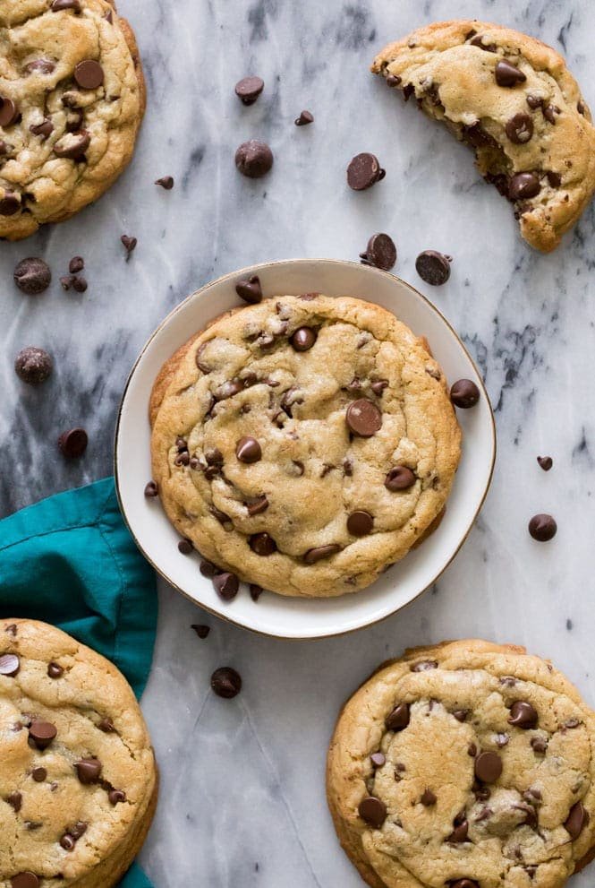How to make GIANT Chocolate Chip Cookies! These have soft and chewy centers and crisp edges! #chocolatechipcookies #cookierecipe #sugarspunrun Giant chocolate chip cookie on plate