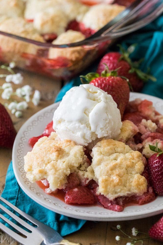 How to make a sweet and simple STRAWBERRY COBBLER! Easy and made completely from scratch, this recipe is a great way to use up summertime berries! #strawberryrecipe #cobblerrecipe #sugarspunrun #summerbaking Strawberry cobbler topped with vanilla ice cream