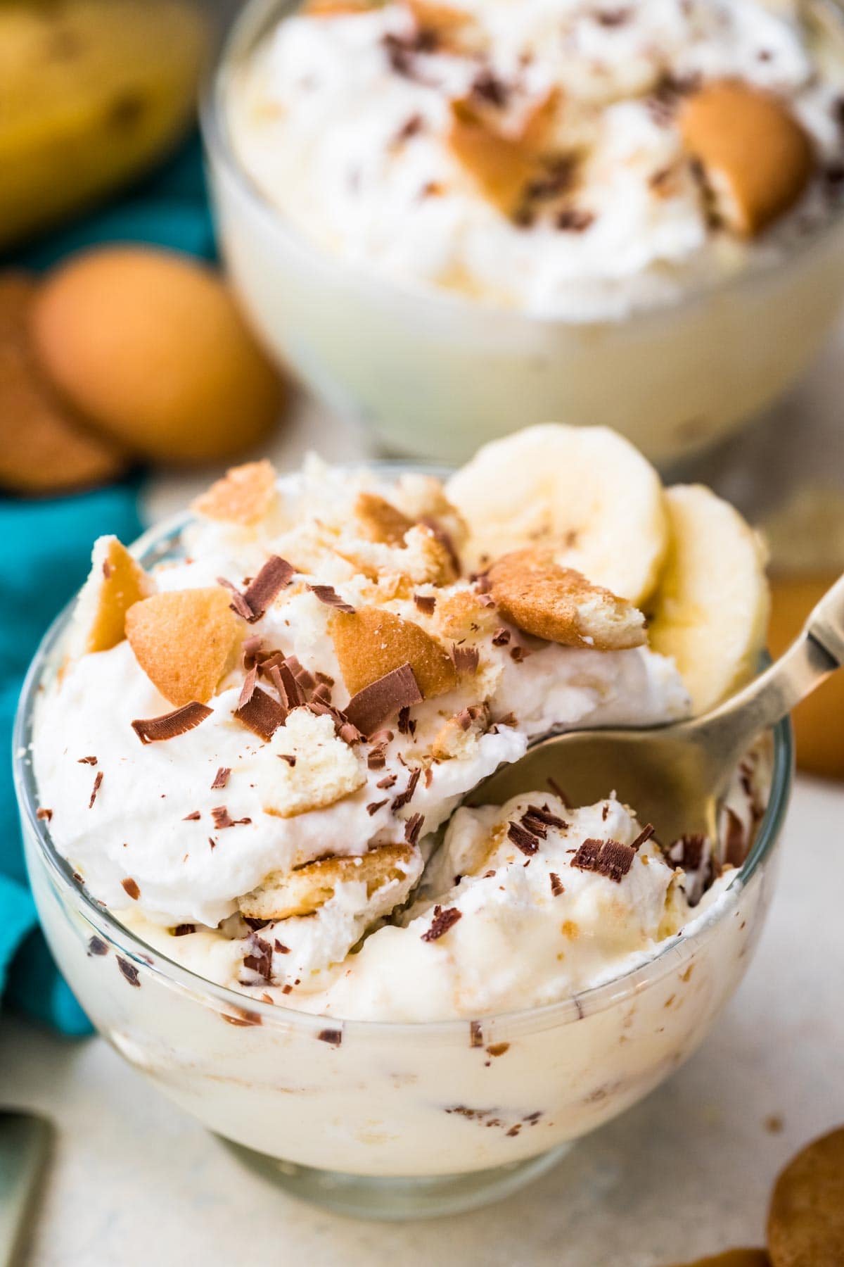 Closeup of homemade banana pudding with a spoon in a clear glass bowl