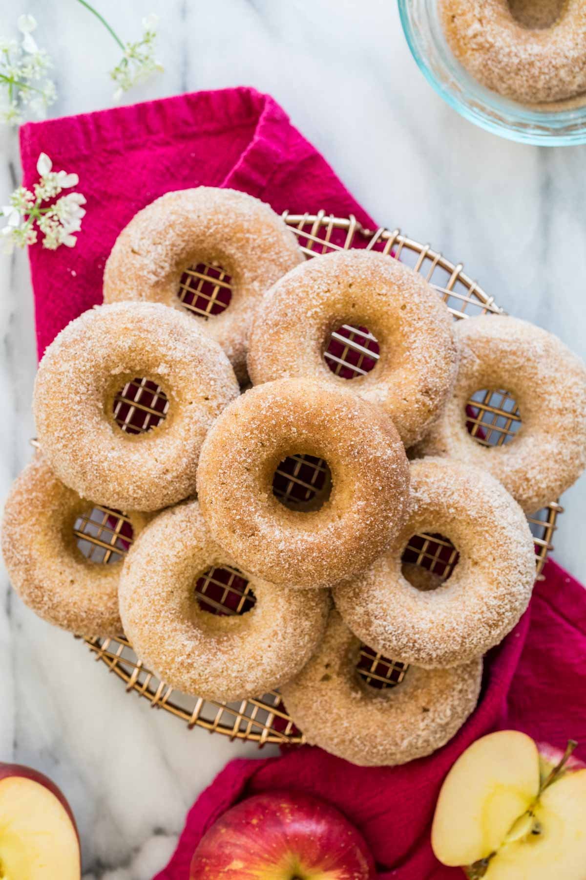 Top-down view of nine apple cider donuts on cooling rack