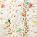Piped ribbons of fruity pebbles frosting with fruity pebbles scattered on top.