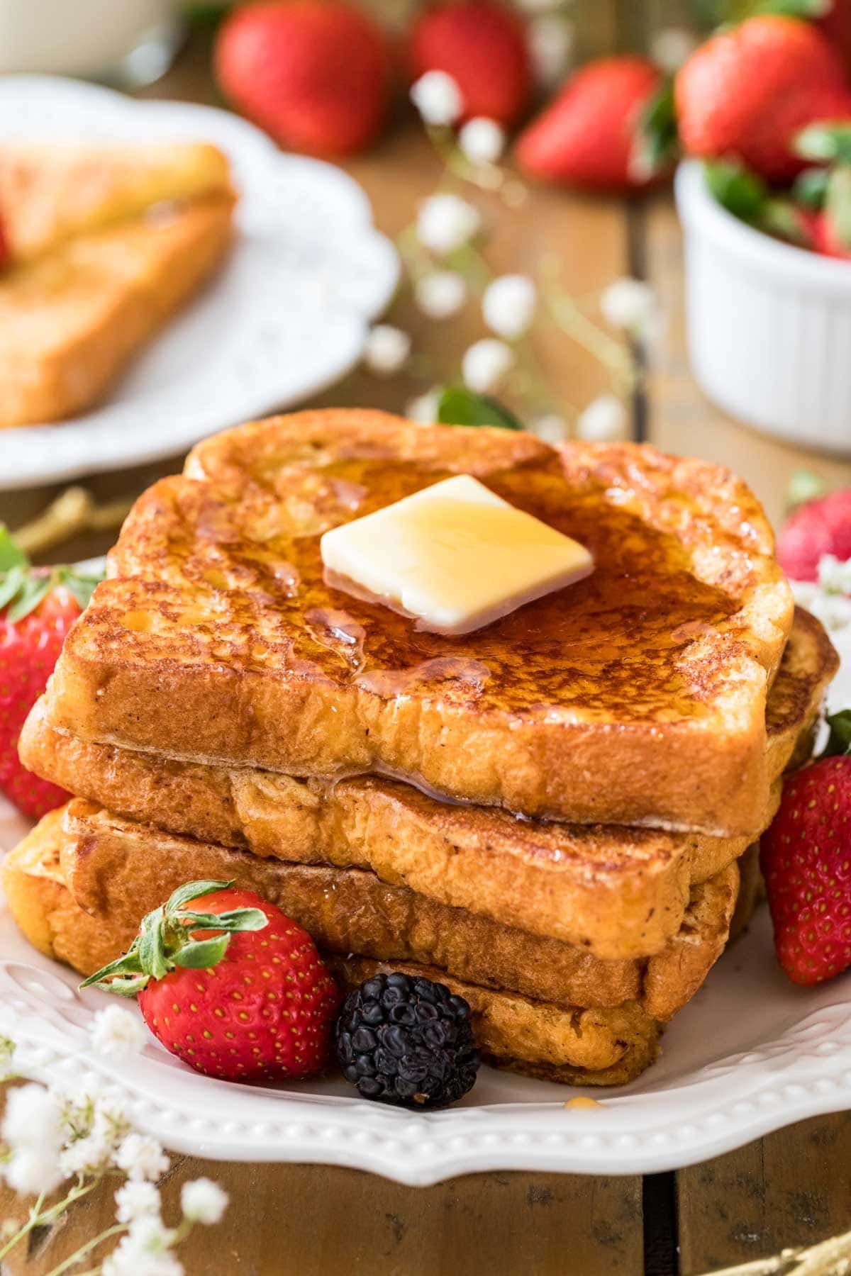 Three slices of my easy french toast recipe with a pat of butter and maple syrup on top.
