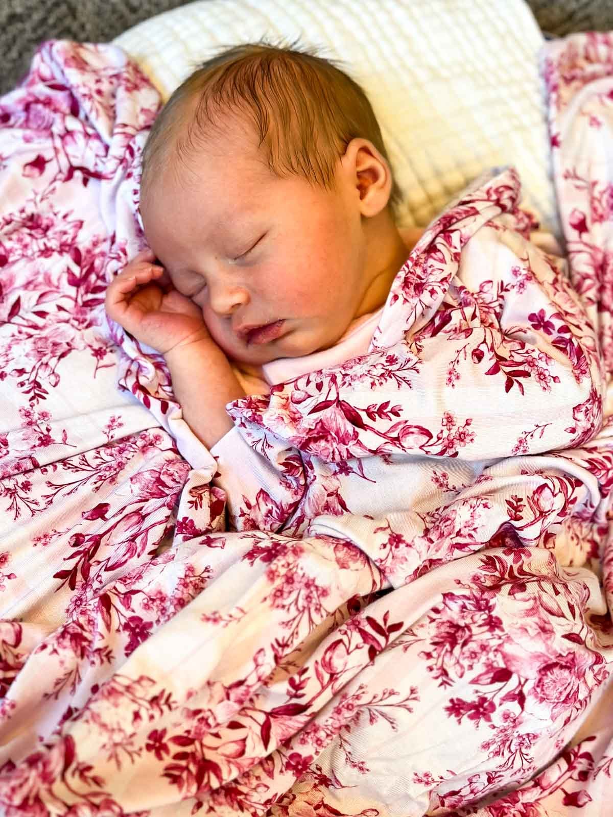 Sleeping baby with pink floral blanket