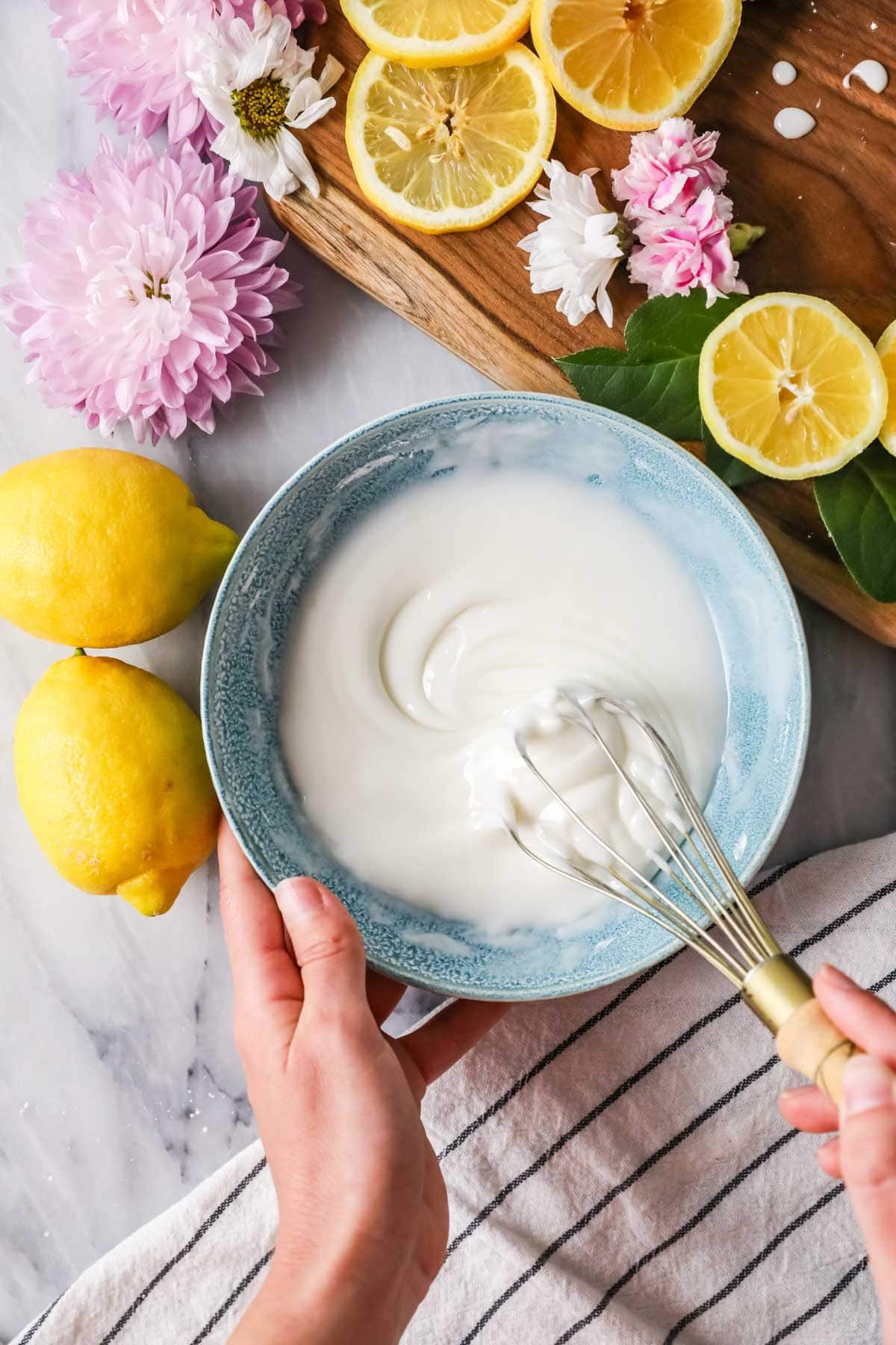 Overhead view of a bowl of lemon glaze being whisked.