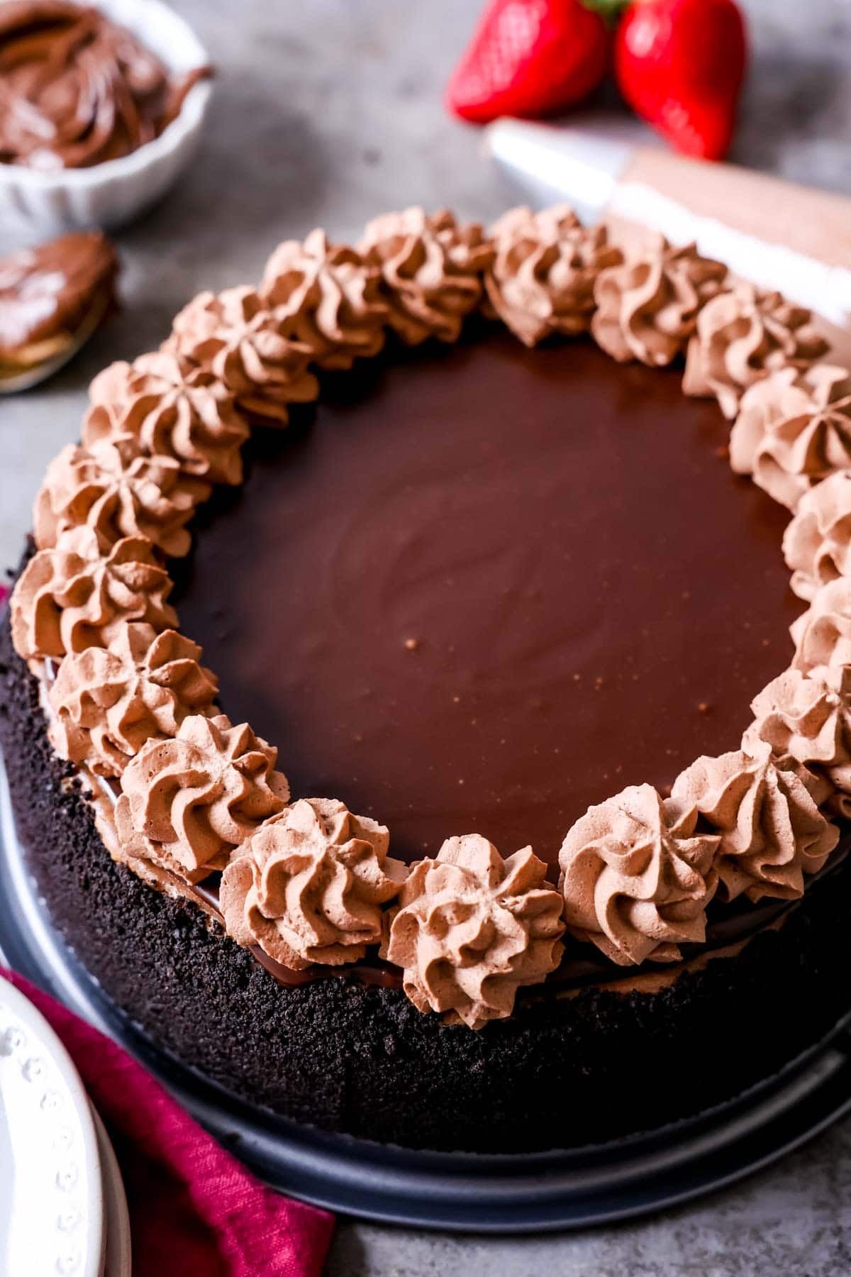 Cheesecake that's been topped with a Nutella ganache and piped dollops of chocolate whipped cream.