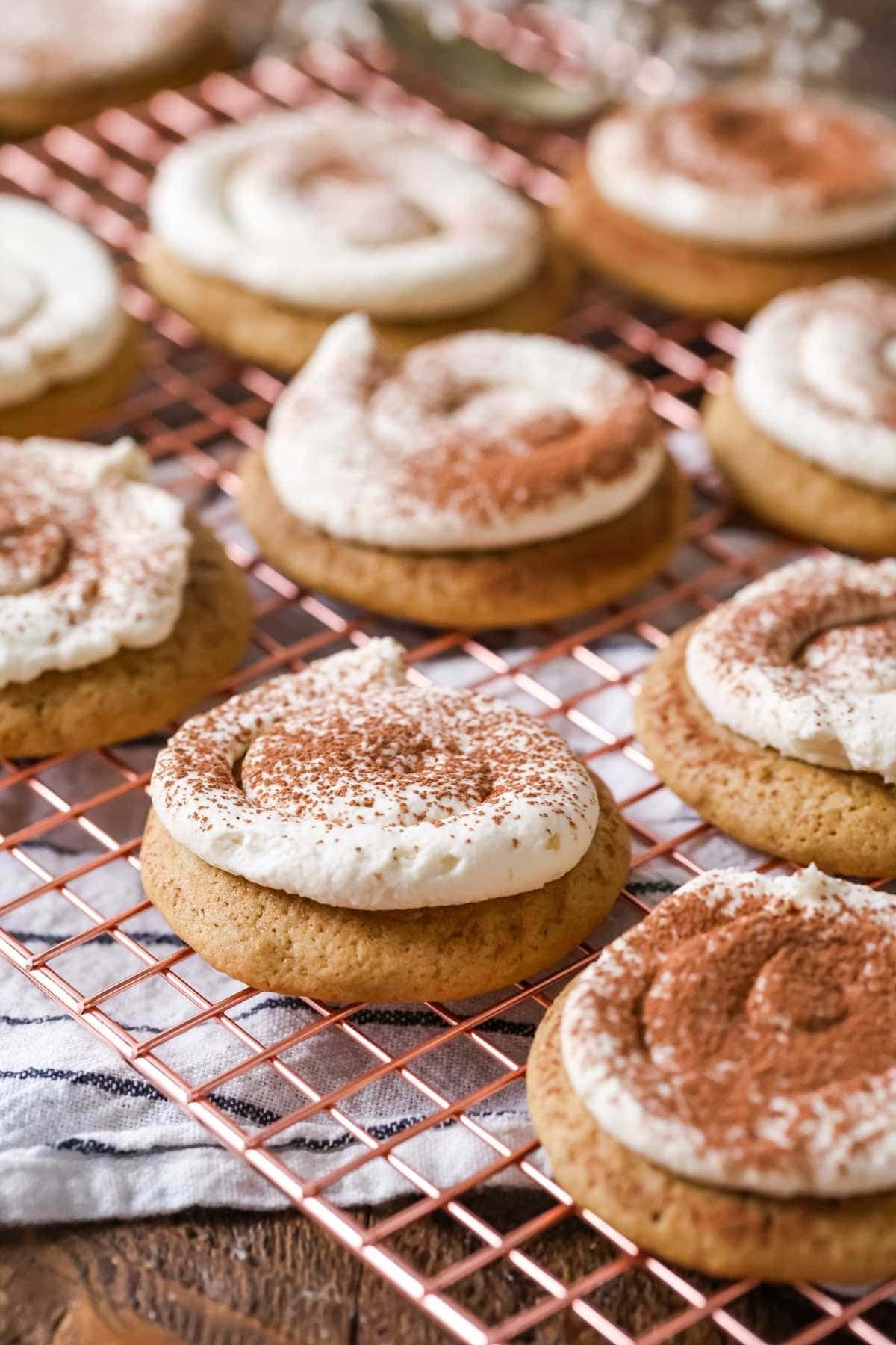 Tiramisu cookies made with espresso soaked cookies and a mascarpone frosting on a cooling rack.