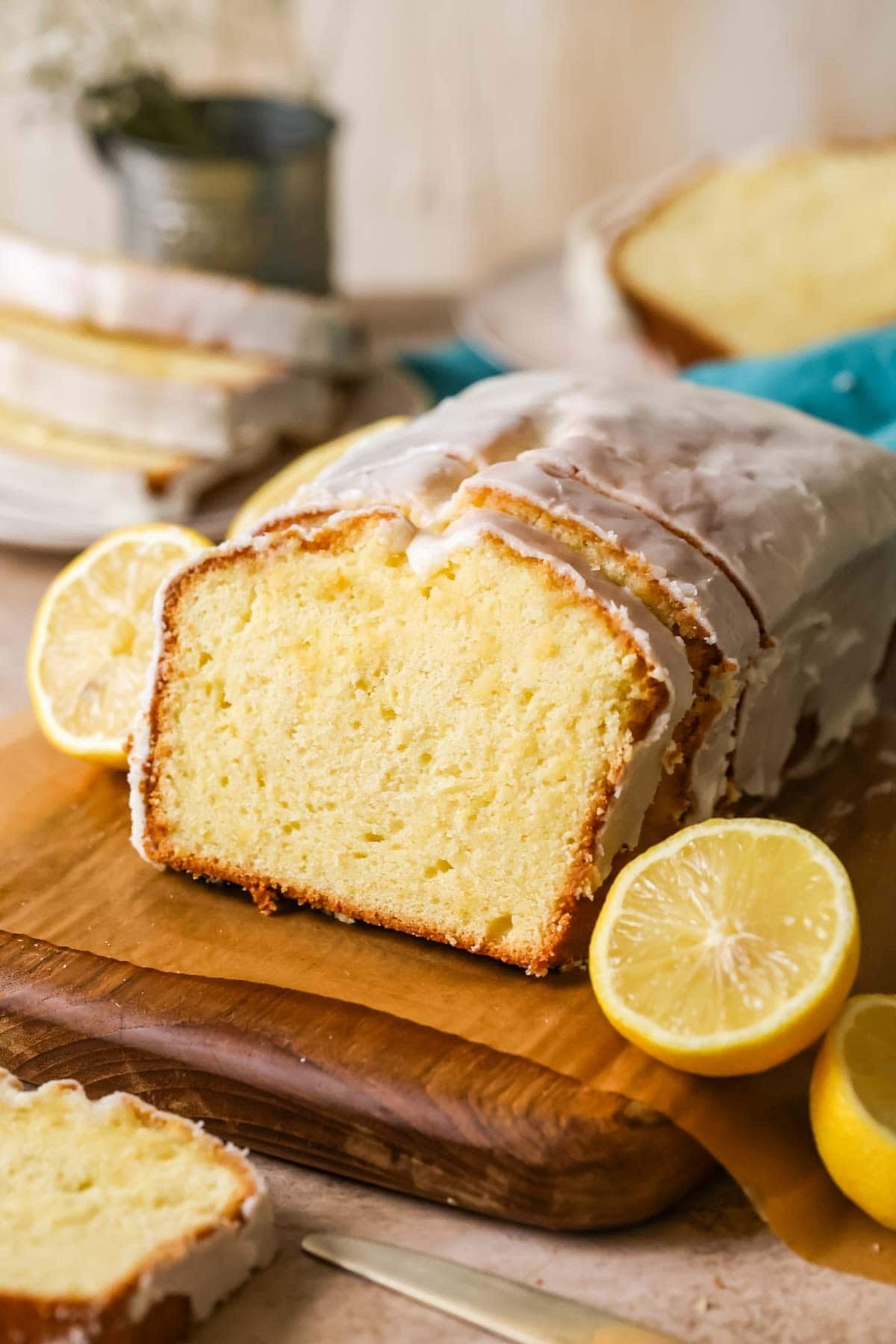 Lemon loaf with a few slices that have been cut and leaned against the loaf.