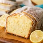 Lemon loaf with a few slices that have been cut and leaned against the loaf.