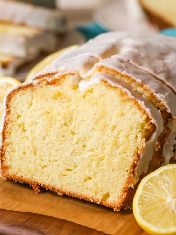 Lemon loaf with a few slices that have been cut and leaned against the loaf.