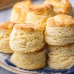 Plate of buttermilk biscuits with tall, flaky layers.