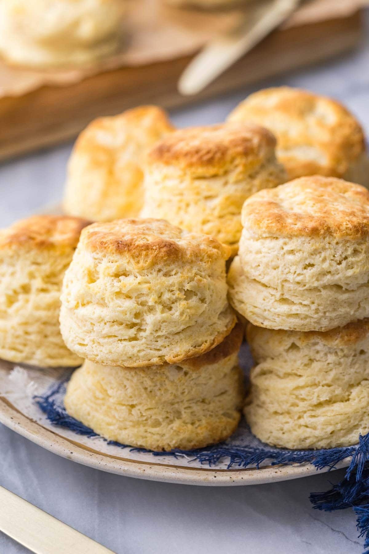 Plate of buttermilk biscuits with tall, flaky layers.
