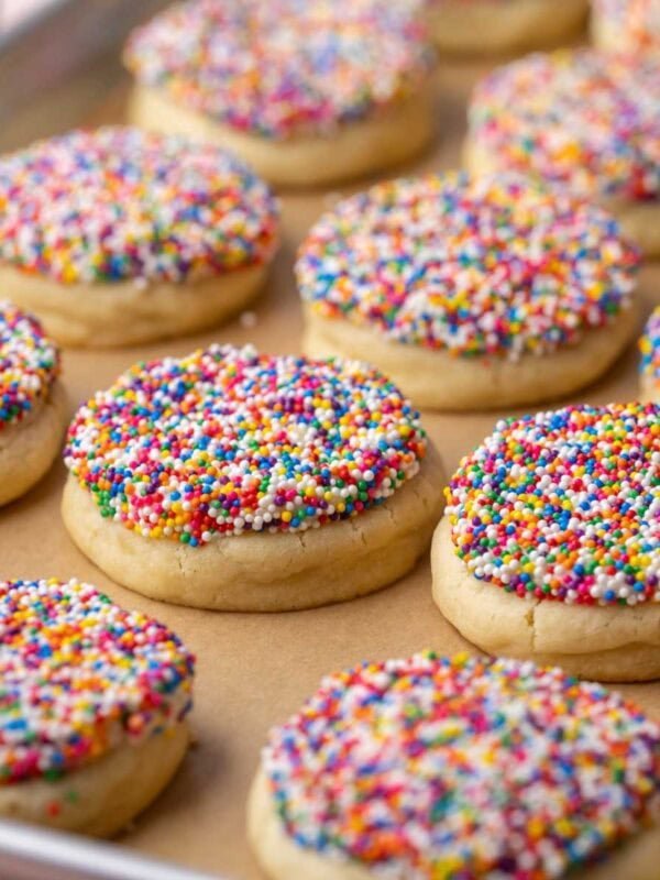 Close-up of dot cake cookies in a parchment lined baking sheet.