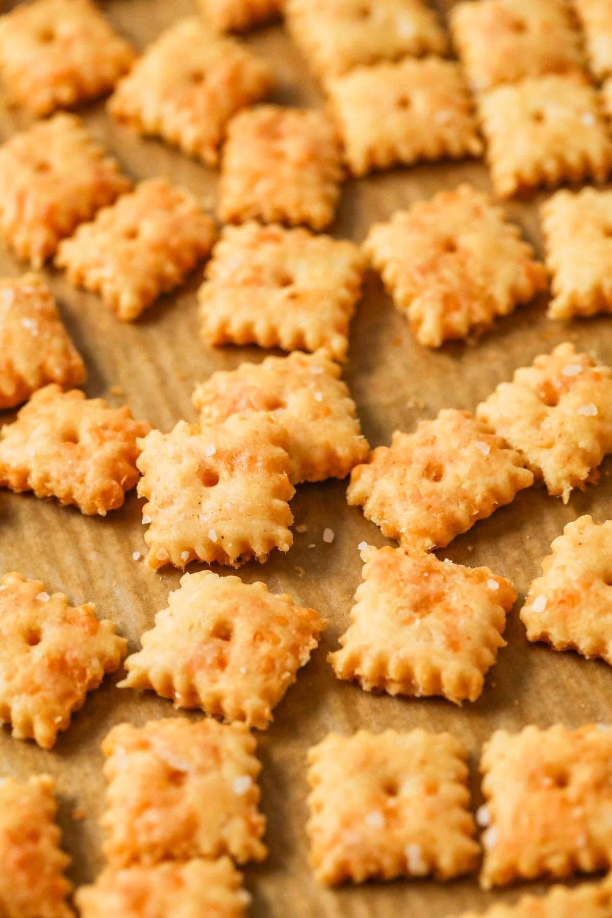 Close-up view of sourdough cheese crackers on a baking sheet.