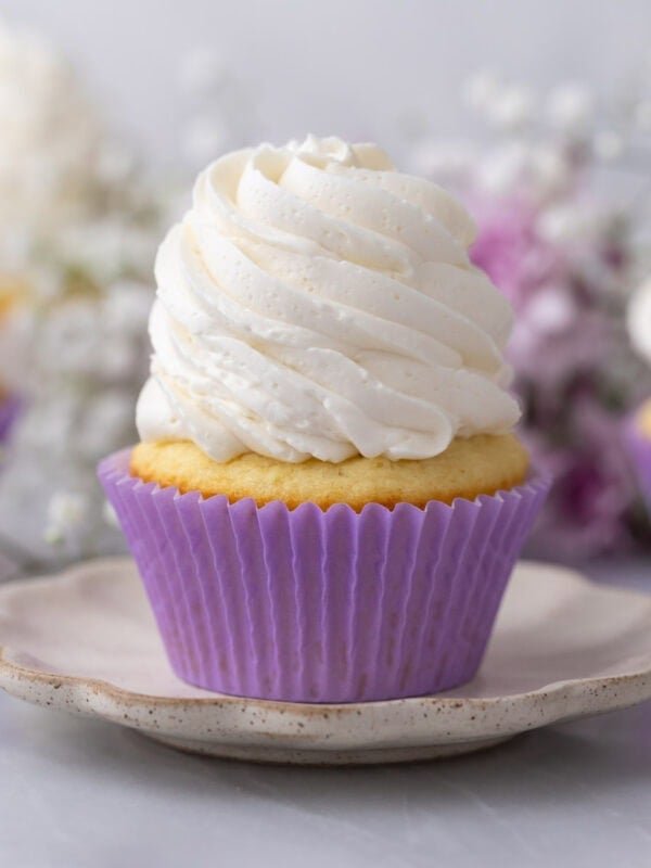 Cupcake topped with a tall swirl of swiss meringue buttercream frosting.